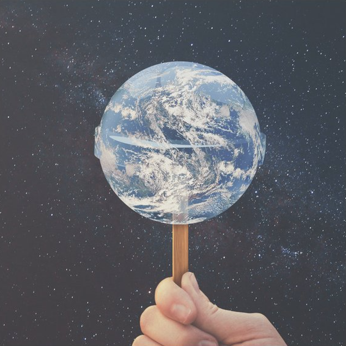 Hand holding lollipop shaped like Earth globe against starry background - visual metaphor representing how the mainstream worldview is fed to masses like candy